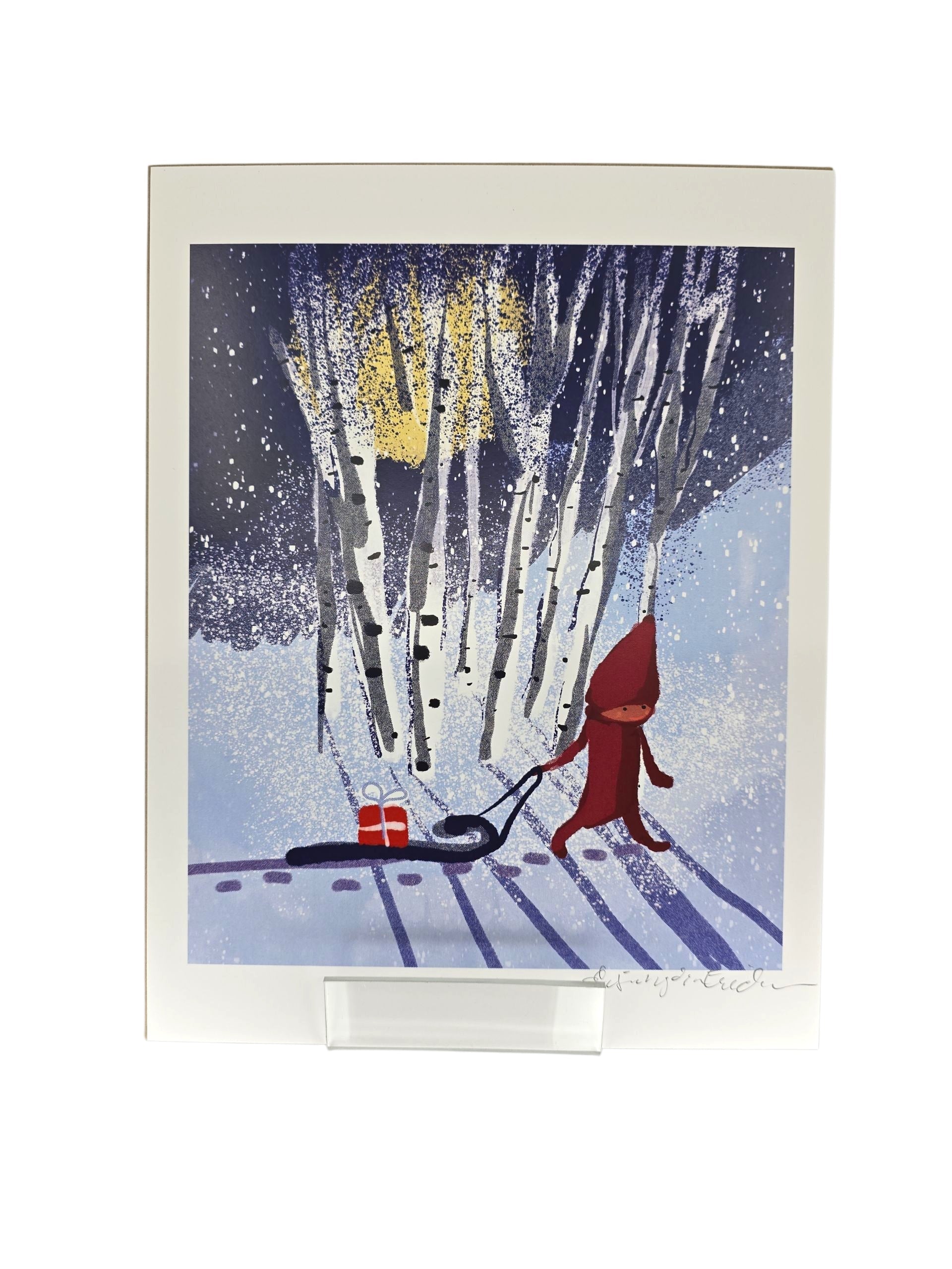 Artwork: Tomten in the Forest Pulling a Sled by Lisa Rydin Erickson (8x10 print) features a red-hooded figure with a sled and gift in a snowy midnight forest, perfect for cozy Swedish holiday decor.